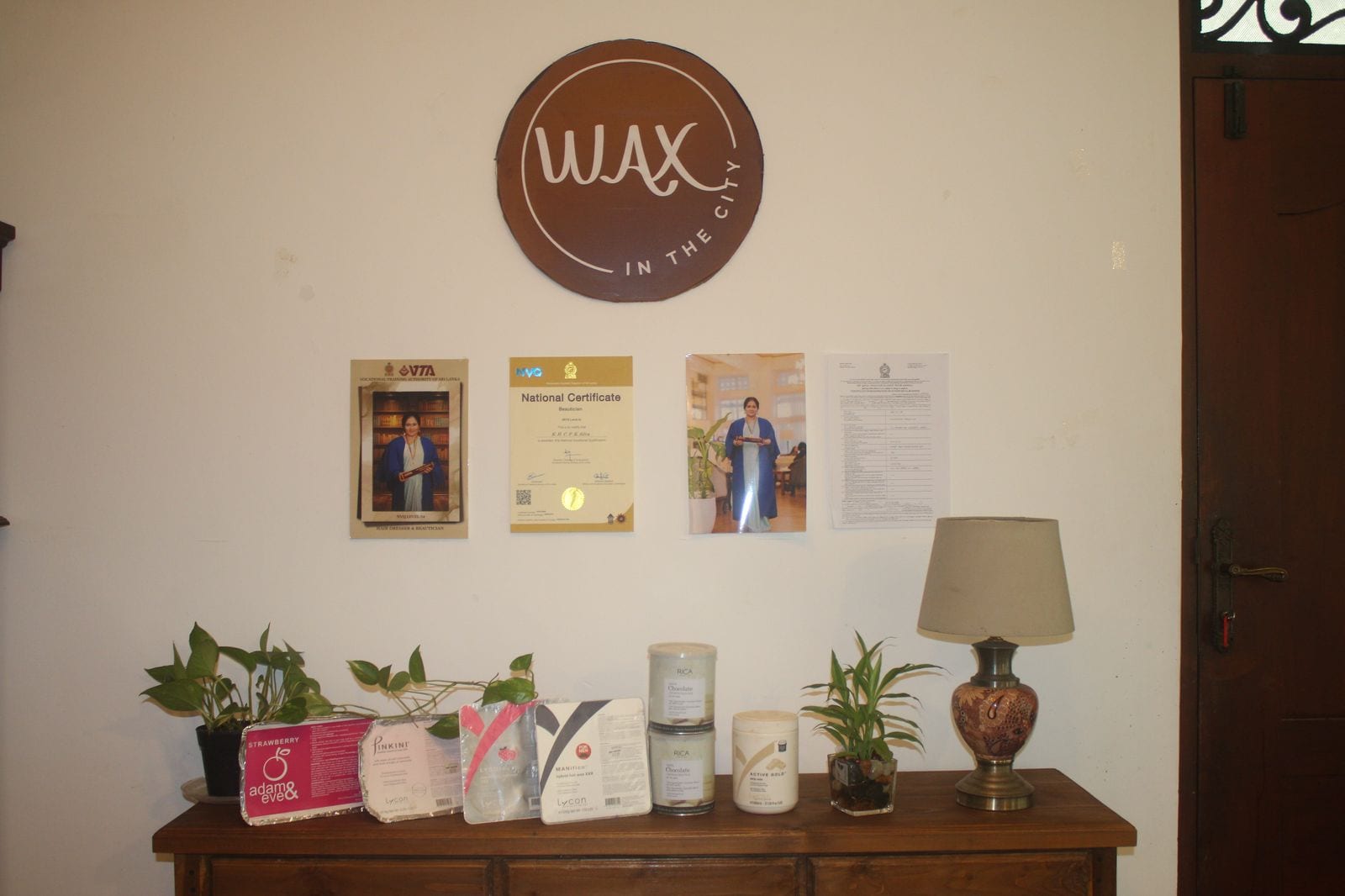 The Wax In The City brand wall with certificates and premium wax products